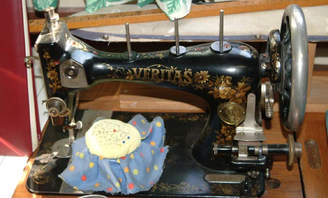 Nähmaschine:  Mit einer Nähmaschine konnten gleichmäßige Nähte produziert werden. Dieses ältere Modell wurde noch auf der rechten Seite an dem silbernen Rad per Hand bewegt, spätere Modelle hatten einen Treibriemen, der durch ein Fußpedal betrieben wurde
